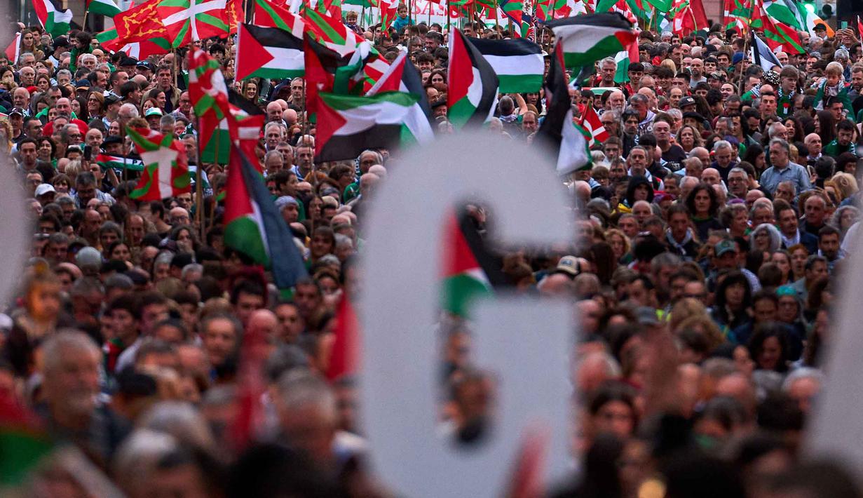 Israel juga mengabaikan seruan internasional dan perintah dari Mahkamah Internasional untuk menghentikan serangan. Tampak dalam foto, para demonstran berbaris untuk memprotes tindakan militer Israel di Gaza, menjelang pertandingan persahabatan antara tim pemain Palestina dan sekelompok pemain Spanyol dari wilayah Basque, di Bilbao, Spanyol, Sabtu 15 November 2025. (AP Photo/Miguel Oses)