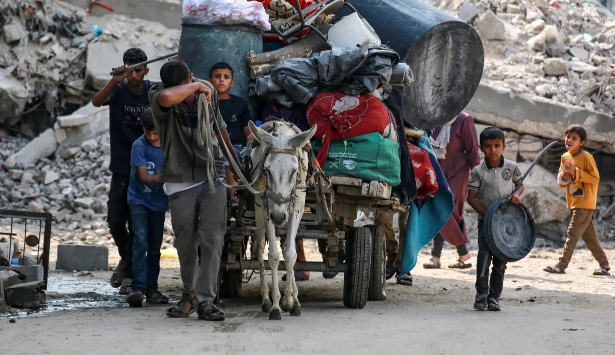 Penduduk Palestina mengangkut barang-barang mereka dengan kereta yang ditarik keledai saat mereka mengungsi dari kawasan Abu Iskandar di bagian utara Kota Gaza pada 22 Agustus 2025. (Bashar TALEB/AFP)