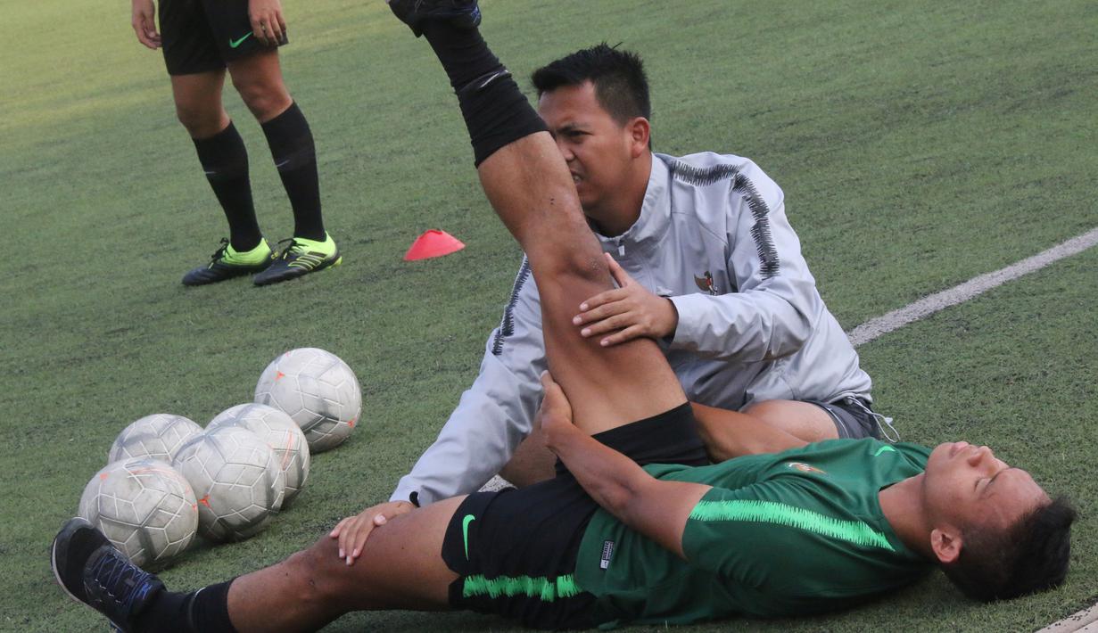 Pemain Timnas Indonesia U-22, Andy Setyo, melakukan perenggangan saat latihan di Stadion National Olympic, Phnom Penh, Sabtu (23/2). Latihan ini persiapan jelang laga semifinal Piala AFF U-22 melawan Vietnam. (Bola.com/Zulfirdaus Harahap)