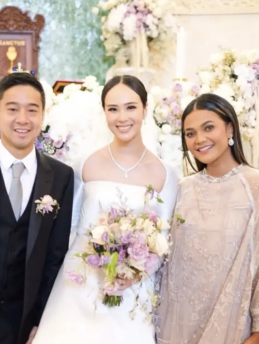 Sementara itu, sang suami tampil gagah dengan setelan jas hitam lengkap dengan inner kemeja putih, dasi abu-abu, dan bros bunga yang serasi dengan buket bunga Pamela. [@citrascholastika]