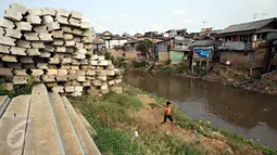 Seorang anak berlari di bantaran Sungai Ciliwung, Jakarta, Selasa (13/10/2015). Berdasarkan data BPS DKI Jakarta, angka kemiskinan di Jakarta tahun 2015 mengalami penurunan 0,16 persen dibandingkan tahun lalu. (Liputan6.com/Immanuel Antonius)