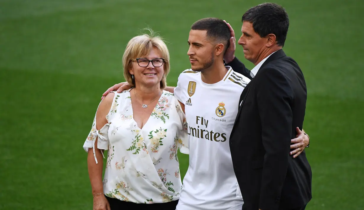 Gelandang Real Madrid, Eden Hazard, bersama kedua orangtuanya saat perkenalan di Stadion Santiago Bernabeu, Madrid, Kamis (13/6). Dirinya didatangkan Madrid dari Chelsea dengan kontrak lima musim. (AFP/Gabriel Bouys)