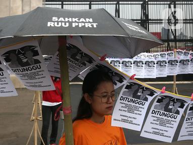 Aktivis Pekerja Rumah Tangga (PRT) melakukan aksi di depan Gedung DPR, Senayan, Jakarta, Rabu (23/8/2023). Aksi dengan memasang instalasi 580 jemuran anggota DPR itu sebagai simbol kepada pimpinan, ketua fraksi, dan anggota DPR RI untuk segera membahas dan mengesahkan Rancangan Undang-Undang Perlindungan Pekerja Rumah Tangga (RUU PPRT). (Liputan6.com/Johan Tallo)