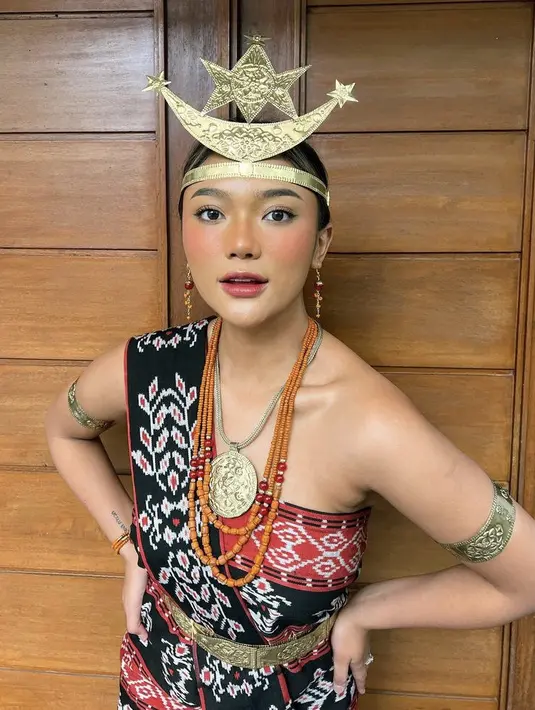 <p>Marion Jola memadukan kain Rote dari Provinsi Nusa Tenggara Timur (NTT) didominasi warna hitam dan merah ini dengan aksesori keemasan berbentuk bulan sabit dipakai di dahi. Selain itu, mengenakan ikat pinggang emas bernama pendi. @lalamarionmj</p>