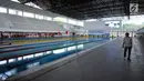 Pewarta melintas di sisi kolam renang di Stadion Aquatik Gelora Bung Karno pasca dilakukan renovasi, Jakarta, Jumat (10/11). Renovasi fisik Stadion Aquatik Gelora Bung Karno dinyatakan selesai dan siap digunakan. (Liputan6.com/Helmi Fithriansyah)