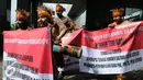 Sejumlah pemuda Papua mengenakan pakaian adat membentangkan spanduk saat menggelar unjuk rasa di depan Gedung KPK, Jakarta, Senin (19/12). (Liputan6.com/Helmi Affandi)