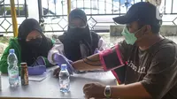 Petugas medis mengecek kesehatan warga sebelum mengikuti program vaksinasi massal Covid-19 di PMI Kota Bekasi, Jawa Barat, Sabtu (21/08/2021). Vaksin yang digunakan dalam vaksinasi massal tersebut yakni vaksin Astrazeneca. (Liputan6.com/Herman Zakharia)