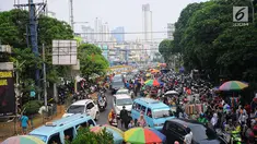 Sejumlah mobil terjebak kemacetan di kawasan Tanah Abang, Jakarta, Minggu (26/5/2019). Banyaknya masyarakat yang berbelanja di pasar tanah abang membuat arus lalu lintas di kawasan tersebut padat. (Liputan6.com/Angga Yuniar)