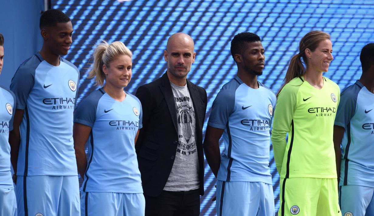 Pelatih Pep Guardiola (tengah) berdiri bersama deretan pemain muda dan pemain wanita Manchester City pada acara perkenalan klub di  City Football Academy, Manchester, (3/7/2016). (AFP/Oli Scarf)