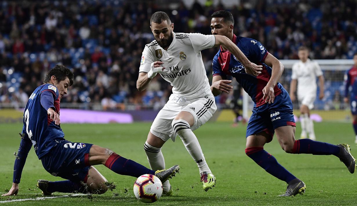 Strker Real Madrid, Karim Benzema, mengontrol bola saat melawan Huesca pada laga La Liga Spanyol di Stadion Santiago Bernabeu, Madrid, Minggu (31/3). Madrid menang 3-2 atas Huesca. (AFP/Javier Soriano)