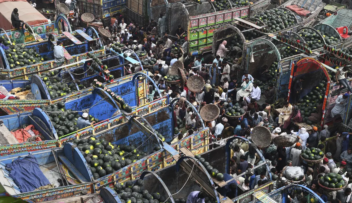 Orang-orang berdagang semangka di pasar buah di Lahore, Pakistan (12/4/2022).  Semangka biasa dipanen buahnya untuk dimakan segar atau dibuat jus. (AFP/Arif Ali)