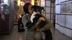 Seorang wanita mencium anjing peliharaannya di dalam gereja San Francisco sebelum pemberkatan hewan di Lima, Peru pada Minggu (6/10/2019). Pemberkatan hewan ini untuk menghormati Santo Fransiskus yang dikenal sebagai santo pelindung bagi binatang dan lingkungan hidup. (AP/Martin Mejia)