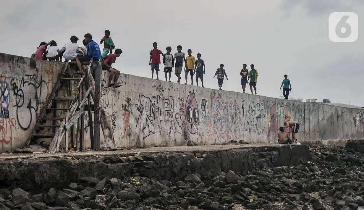 Anak-anak bermain di tanggul laut Muara Baru, Jakarta, Rabu (19/1/2022). Badan Pusat Statistik (BPS) mencatat angka kemiskinan di Indonesia turun menjadi 26,5 juta orang per September 2021 dari sebelumnya mencapai 27,54 juta orang pada Maret 2021. (merdeka.com/Iqbal S Nugroho)