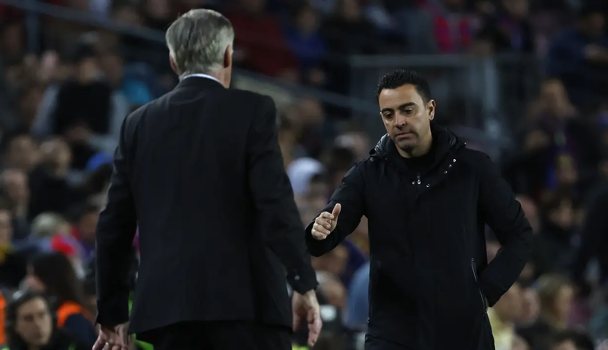 Pelatih Barcelona, Xavi Hernandez menghampiri pelatih Real Madrid, Carlo Ancelotti untuk memberi ucapan selamat setelah berakhirnya laga leg kedua semifinal Copa del Rey 2022/2023 di Camp Nou Stadium, Barcelona, Kamis (6/4/2023) dini hari WIB. (AP Photo/Joan Monfort)