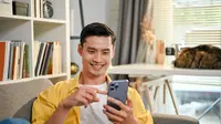 Seorang pria menggunakan smartphone. (Shutterstock/BongkarnGraphic)