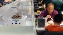 Pengunjung menunggu makanan yang akan diantarkan oleh robot di restoran Robot.He milik Alibaba di Shanghai, 30 Juli 2018. Robot pintar yang sebesar oven microwave bertugas menerima pesanan dan mengantarkan makanan di atas nampan kepada para tamu. (AFP)