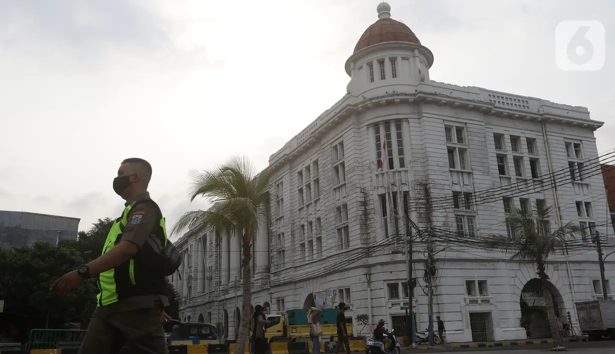 Petugas Satpol PP berjalan di sekitaran Jalan Kali Besar Barat kawasan Kota Tua, Jakarta, Minggu (19/9/2021). Meski Jakarta masih dalam masa PPKM level 3, kawasan ini mulai ramai dikunjungi warga untuk berwisata atau sekedar berfoto. (Liputan6.com/Helmi Fithriansyah)
