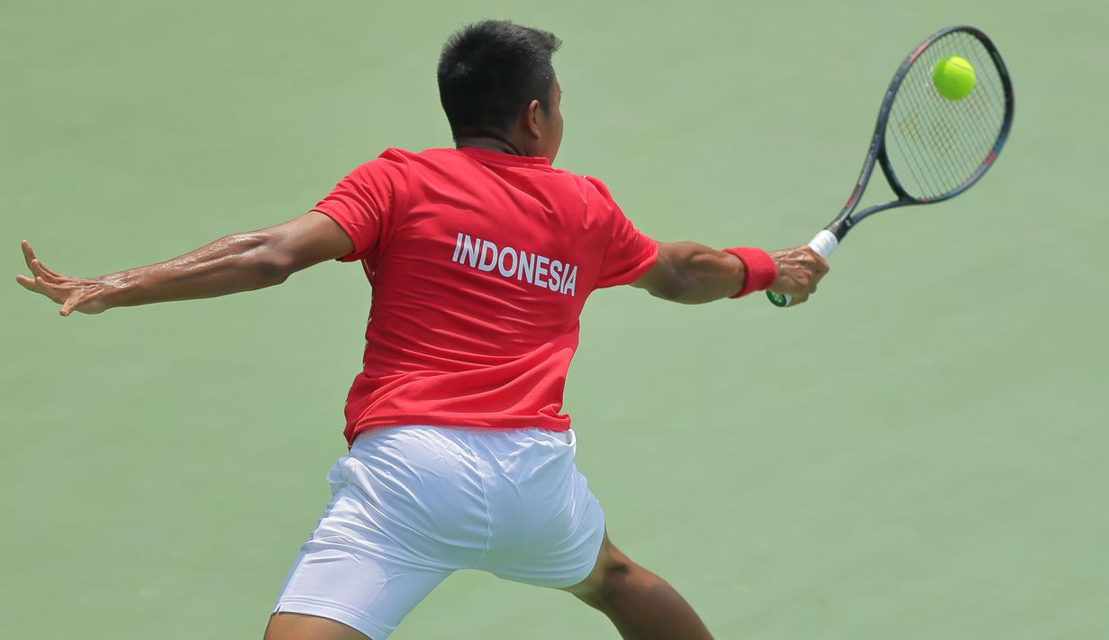 Petenis Indonesia, M. Rifqy Fitriadi, berusaha mengembalikan bola saat melawan petenis Selandia Baru, Ajeet Rai, pada laga Piala Davis 2019 Grup II Zona Asia/Oceania di Stadion Tenis GBK, Jakarta, Sabtu (14/9). Rifqi kalah 6-7, 3-6 dari Ajeet. (Bola.com/Peksi Cahyo)