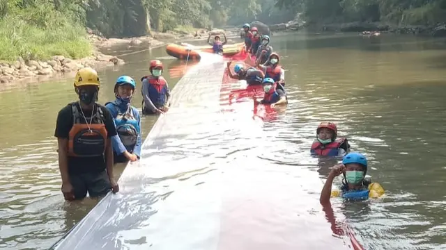 Aksi Komunitas Ciliwung Bogor Bentangkan Bendera 33 Meter di Sungai