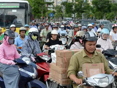 Para pengendara motor melintasi persimpangan jalan di pusat kota Hanoi, 4 Juli 2017. Ibu Kota Vietnam akan melarang sepeda motor di distrik metropolitan mulai 2030 guna mengurangi kemacetan lalu lintas dan polusi. (AFP PHOTO/HOANG DINH Nam)