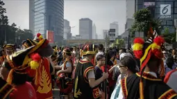 Warga mengenakan atribut budaya Kepulauan Nias saat Car Free Day di Kawasan Jalan Sudirman, Jakarta, Minggu (4/3). Pagelaran ini untuk memperkenalkan kebudayaan Kepulauan Nias oleh para pemuda asal Nias se-Jabodetabek. (Liputan6.com/Faizal Fanani)