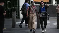 Dua wanita berjalan mengenakan masker pelindung untuk menghindari polusi udara buruk di Jakarta, Rabu (17/7/2019). Dinkes DKI menyarankan masyarakat untuk menggunakan masker saat beraktivitas untuk mencegah dampak polusi udara pada tubuh. (Liputan6.com/Faizal Fanani)