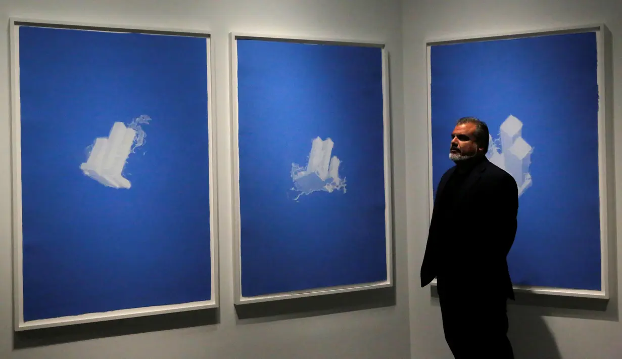 Seniman Christopher Saucedo berdiri di dekat karya lukisnya yang berjudul 'World Trade Center as a Cloud' yang dipamerkan di National September 11 Memorial and Museum, Manhattan, AS (1/9). (REUTERS/Andrew Kelly)