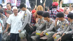 Petugas polisi berbincang dengan pengunjung sidang lanjutan Basuki Tjahaja Purnama (Ahok) di Gedung Kementerian Pertanian, Jakarta, Selasa (3/1). Sedikitnya 2.500 personel kepolisian disiagakan di lokasi sidang keempat itu. (Liputan6.com/Helmi Afandi)
