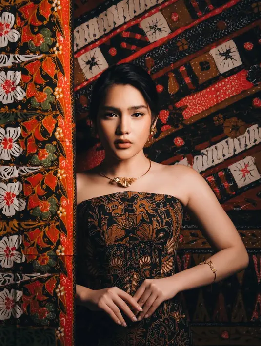 Berbeda dari yang lain, Davina Karamoy hadir dengan interpretasi batik yang lebih dramatis dan fashion forward. Ia mengenakan gaun strapless hitam dengan detail korset bermotif batik cokelat yang membentuk siluet tubuh secara tegas. [@davinakaramoy].