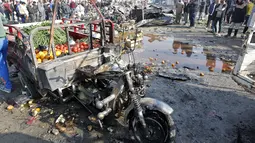 Kendaraan untuk membawa sayur rusak akibat ledakan bom di pasar sayur Jumila di Baghdad, Irak (8/1). Pihak kepolisian Baghdad mengatakan, lokasi serangan terjadi di lingkungan yang dihuni oleh para penganut Syiah. (AFP/Sabar Arar)