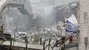 Bendera Israel terlihat selama penghancuran bangunan Palestina di daerah Wadi al-Hummus yang berdekatan dengan Palestina (22/7/2019). Palestina menuduh Israel menggunakan keamanan sebagai dalih untuk mengusir mereka dari Tepi Barat. (AFP Photo/Ahmad Gharabli)