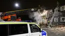 Petugas pemadam menggunakan mobil tangga saat berusaha memadamkan api yang membakar tempat pengungsian di Fagersjo, Stockholm, Swedia pada Minggu (16/10) malam. (REUTERS/TT News Agency / Johan Nilsson)