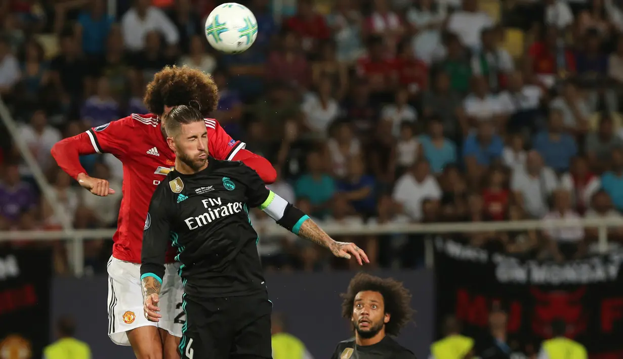Gelandang Manchester United (MU), Marouane Fellaini berusaha menyundul bola dalam laga Piala Super Eropa melawan Real Madrid di Macedonia, Selasa (8/8). Madrid keluar sebagai juara usai menundukkan MU dengan skor 2-1. (AP/Boris Grdanoski)
