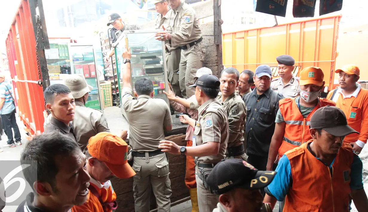 Petugas Satpol PP mengeluarkan barang-barang yang berada di kios Kavling 36 Pasar Benhil, Jakarta, (29/8/2015). Pembongkaran dilakukan berdasarkan putusan PTUN Jakarta yang memenangkan PD Pasar Jaya. (Liputan6.com/Gempur M Surya)