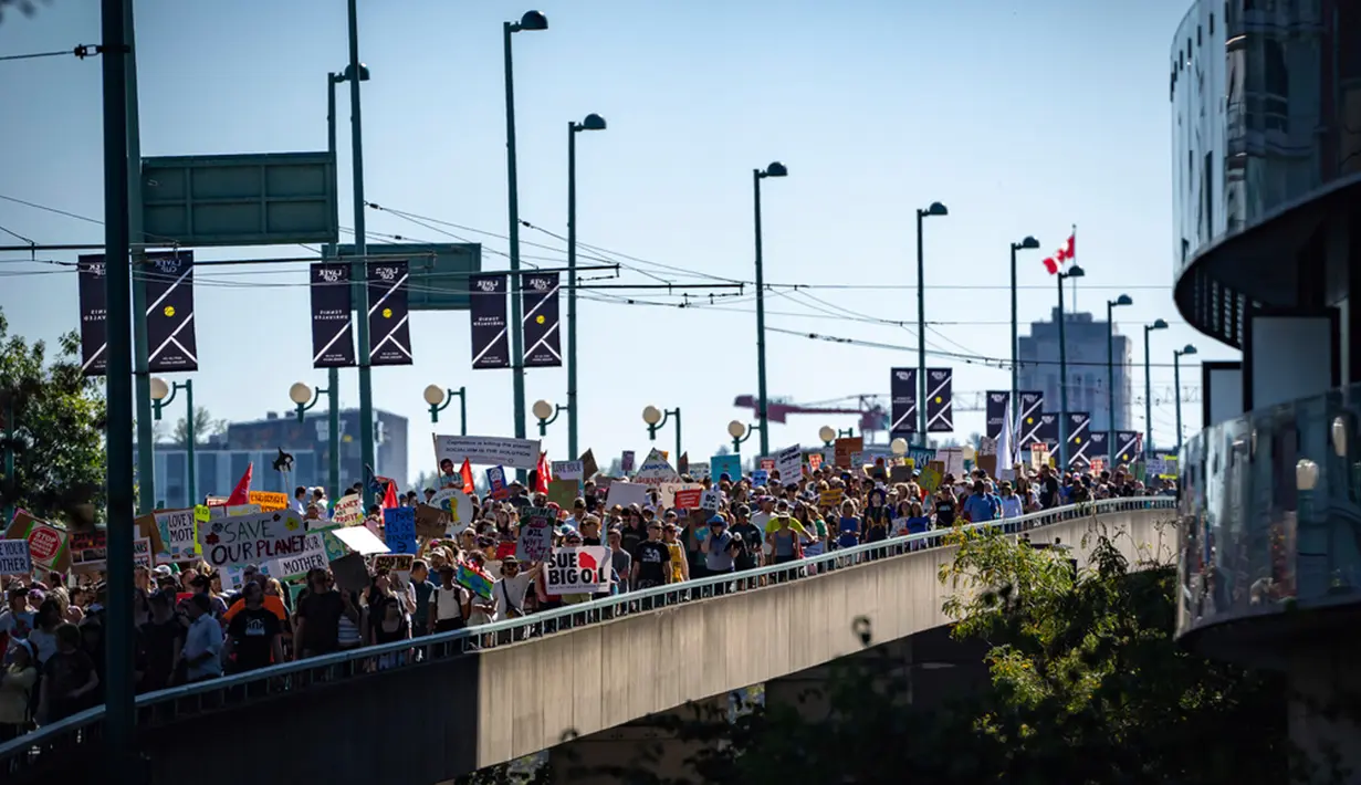 Orang-orang berbaris melintasi Cambie Street Bridge saat protes Global Climate Strike di Vancouver, British Columbia, Kanada, Jumat (15/9/2023). Global Climate Strike 2023 digelar mulai dari Indonesia, Pakistan, Nigeria, hingga Amerika Serikat (AS), pengorganisir aksi menyebutkan ada lebih dari 500 aksi di 54 negara. (Ethan Cairns/The Canadian Press via AP)