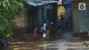 Warga membersihkan rumah dari sisa lumpur  di Bukit Duri, Jakarta, Jumat (29/10/2021). Hujan dengan intensitas tinggi beberapa hari lalu membuat aliran sungai ciliwung meluap yang merendam sebagian rumah warga yang tinggal di bantaransungai  tersebut. (merdeka.com/Imam Buhori)