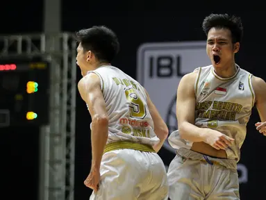 Pemain West Bandits Combiphar Solo, P. Nikolas (kanan) dan R. Disi melakukan selebrasi usai mencetak poin saat laga pekan pertama IBL Tokopedia 2022 melawan Rans PIK Basketball di Hall Basket Gelora Bung Karno, Senayan, Sabtu (15/01/2022). (Bola.com/Bagaskara Lazuardi)