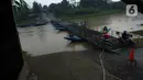 Pengendara sepeda motor melintasi jembatan perahu di atas Sungai Citarum, Karawang, Jawa Barat, Sabtu (20/11/2021). Tarif sekali melewati jembatan perahu ini dipatok Rp 2.000 per sepeda motor dan Rp 1.000 bagi pejalan kaki. (merdeka.com/Imam Buhori)