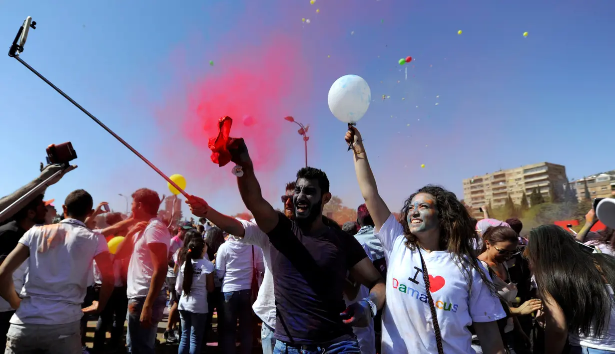 Peserta bersuka cita saat mengikuti acara marathon bertajuk 'I Love Damaskus' di Umayyah Square Damaskus, Suriah, Jumat (7/10). (REUTERS / Omar Sanadiki)