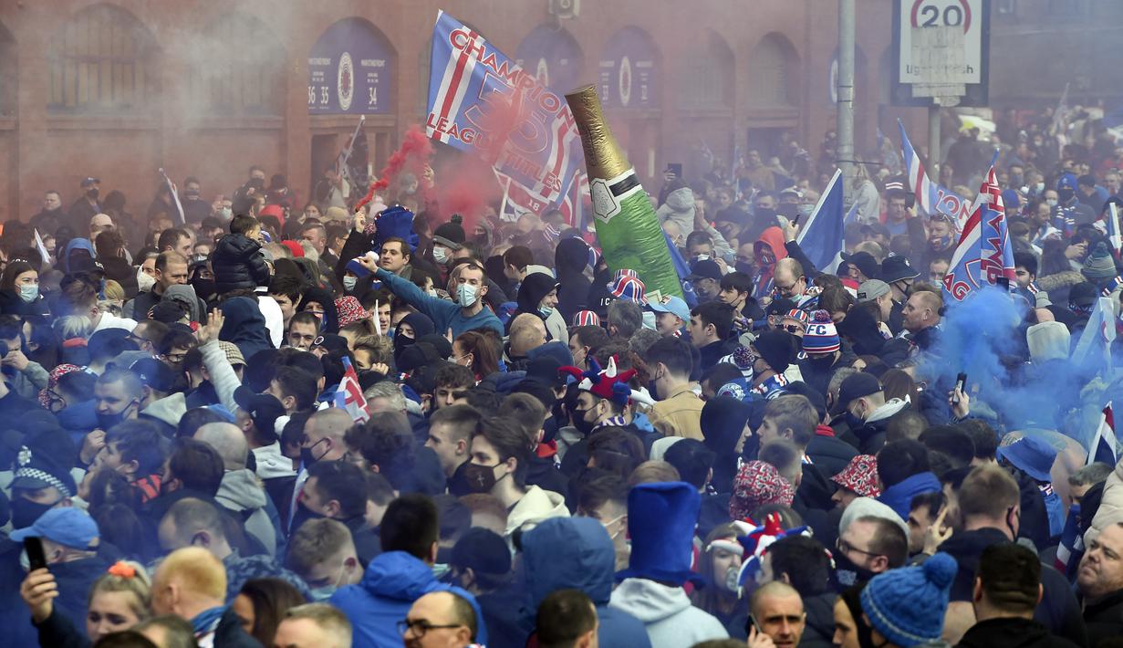 Suporter merayakan kemenangan usai klub sepak bola kebanggan mereka, Rangers menjuarai Liga Skotlandia 2020/2021. Ini merupakan gelar juara liga pertama bagi The Gers dalam 10 tahun terakhir. (Foto: AFP/Andy Buchanan)
