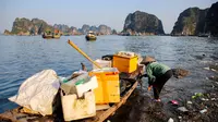 Dalam foto file yang diambil pada 17 Mei 2023 tampak seorang pekerja memungut sampah dari Ha Long Bay di timur laut Vietnam.&nbsp;(Nam NGUYEN/AFP)