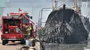 Petugas pemadam kebakaran melakukan pendinginan kapal yang ludes dilalap api di Pelabuhan Muara Baru, Jakarta, Minggu (24/2). Hingga kini belum diketahui penyebab pasti kebakaran tersebut. (Merdeka.com/Iqbal Nugroho)