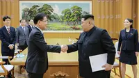 Pemimpin Korut Kim Jong-un bersalaman dengan Kepala Delegasi Korsel Chung Eui-yong usai menerima kunjungannya di Pyongyang (5/3). Sebelumnya, penurunan ketegangan antar kedua Korea terjadi di tengah momen Olimpiade Musim Dingin bulan lalu. (AFP/Handout)