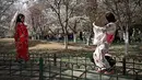 Gadis-gadis China mengenakan kimono khas Jepang berfoto dengan latar belakang bunga sakura selama festival musim semi di Taman Yuyuantan, Beijing, China, Sabtu (30/3). (AP Photo/Andy Wong)