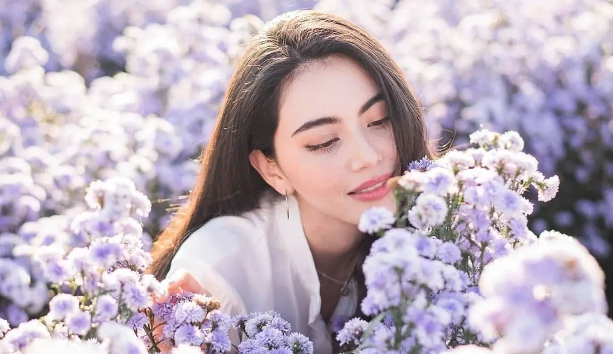 Davika Hoorne terlihat begitu menawan saat berada di antara bunga-bunga dengan kelopak kombinasi ungu dan putih. Gaya penampilan Davika ini banjir pujian dari netizen yang menyebutnya kian memesona. (Liputan6.com/IG/@davikah)