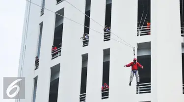 Petugas damkar melakukan teknik flying fox saat simulasi penanggulangan kebakaran di Senayan City, Jakarta, Kamis (26/11). Simulasi dilakukan untuk melatih kesiap-siagaan pengelola pusat belanja dalam menghadapi kebakaran. (Liputan6.com/Gempur M Surya)