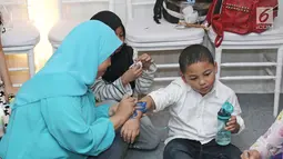 Anak kedua Krisdayanti dengan Raul Lemos, Kellen saat tangannya dilukis di kawasan Tebet, Minggu (27/08). Anak-anak ini asyik bermain saat menghadiri acara potong rambut anak kedua Ayu Dewi. (Liputan6.com/Herman Zakharia)