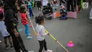 Anak-anak bermain permainan tradisional ditemani sejumlah mahasiswa dari Penggerak Olahraga saat car free day (CFD) di kawasan Bundaran HI, Jakarta, Minggu (14/7/2019). Kegiatan yang rutin digelar ini bertujuan mengajak masyarakat DKI Jakarta aktif berolahraga. (Liputan6.com/Faizal Fanani)