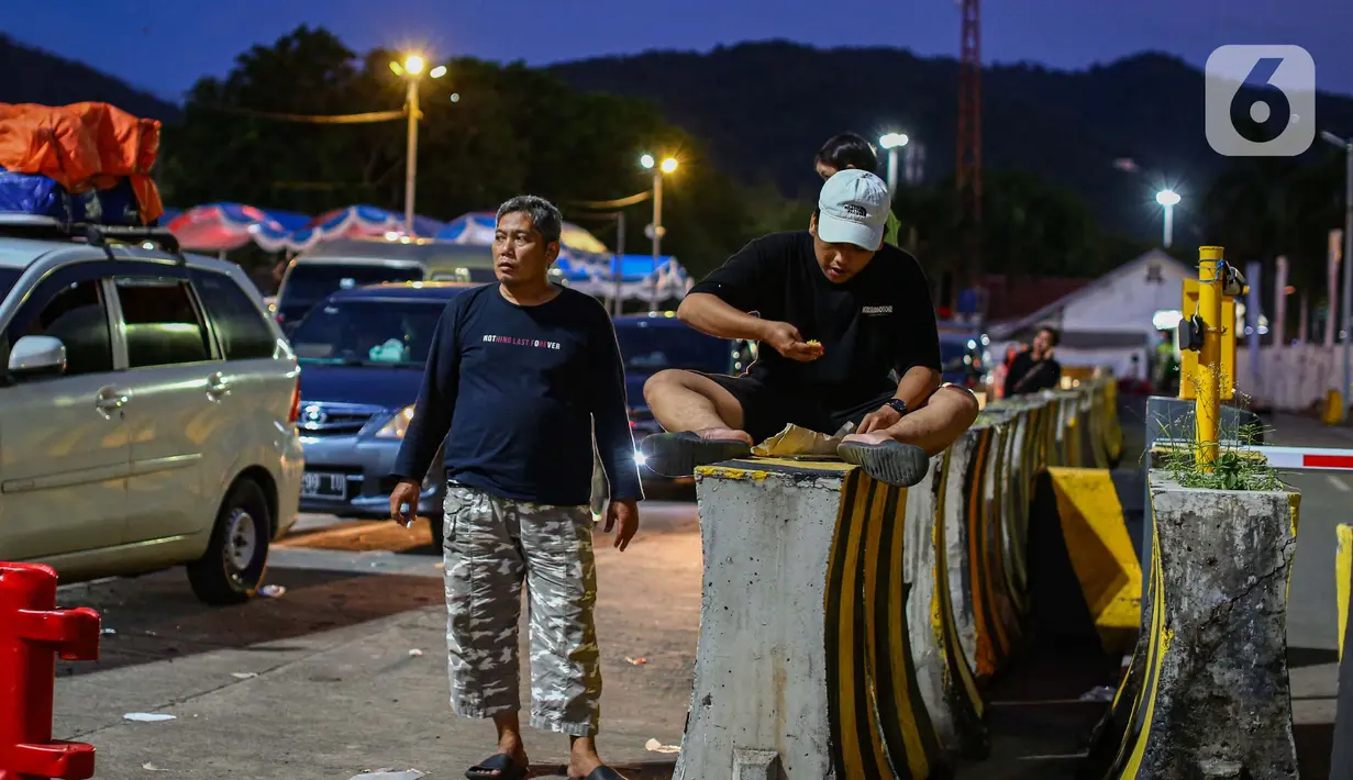 Terlihat pemudik makan malam bersama di pembatas jalan dekat kendaraan mereka. (Liputan6.com/Angga Yuniar)