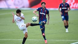 Pemain Sevilla, Jesus Navas, berusaha menghadang tendangan bek Levante, Tono, pada laga La Liga di Estadio Camilo Cano, Selasa (16/6/2020). Kedua tim bermain imbang 1-1. (AFP/Jose Jordan)